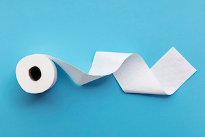 A single roll of toilet paper unrolled on a blue background