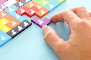 image of tangram puzzle blocks with people icons over wooden table ,human resources and management concept.