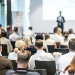 Male business speaker giving a talk at business conference event.